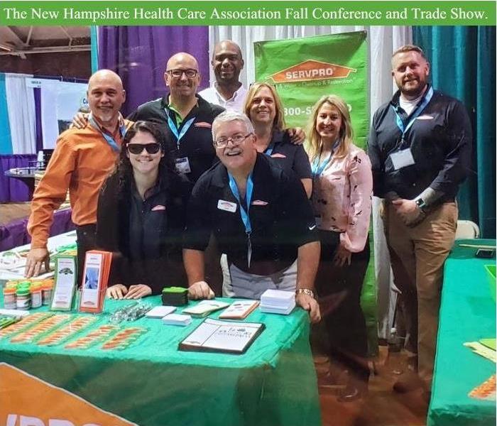 multiple people standing behind table at SERVPRO event