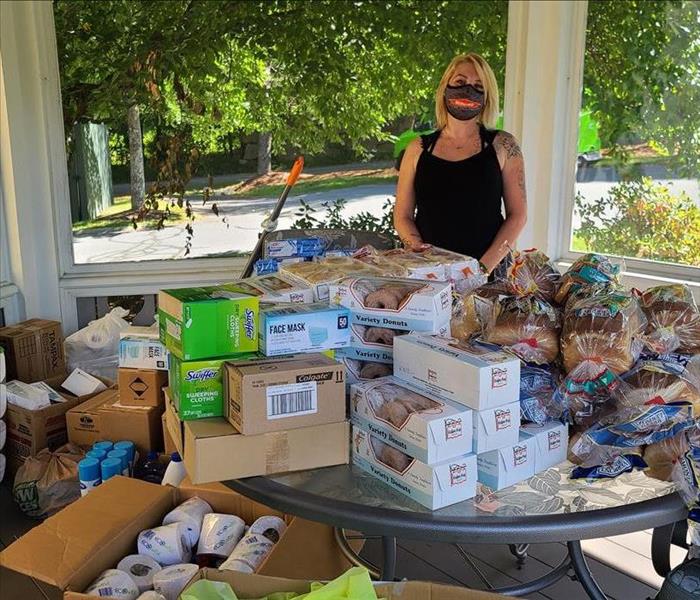 SERVPRO employee standing behind donated items 