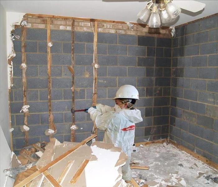 Girl using hammer to knock down a wall