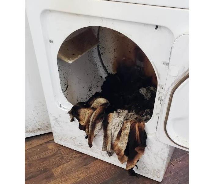 Picture of dryer with burnt clothes inside