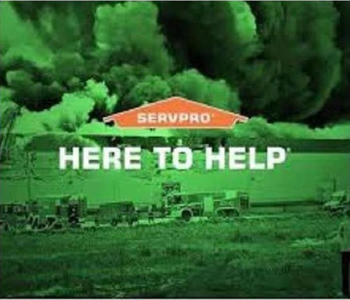 Green SERVPRO here to help poster with storm clouds and SERVPRO vehicles