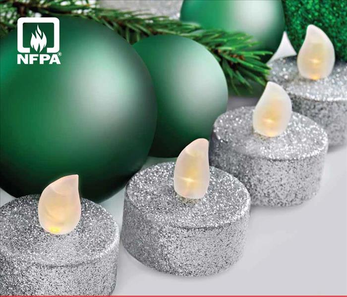 image of short silver battery operated candles in front of green decorations
